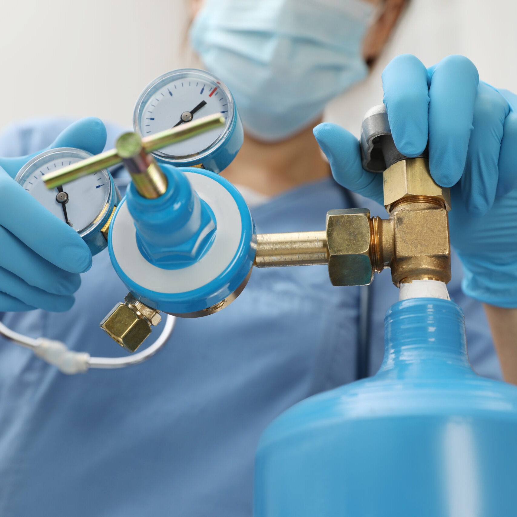 Medical worker checking oxygen tank in hospital room, closeup